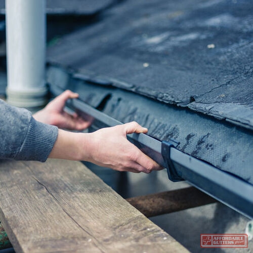 Worker Repairs a Roof Drain